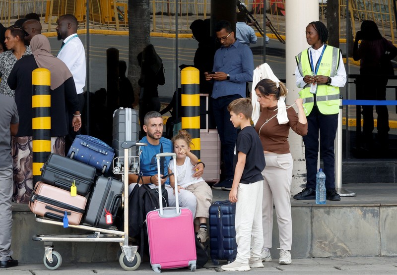 Para pelancong berjalan membawa bagasi mereka setelah operasional penerbangan terganggu akibat aksi mogok kerja karyawan di Bandara Internasional Jomo Kenyatta (JKIA) di Nairobi, Kenya, pada 30 Agustus 2026. (REUTERS/Monicah Mwangi)