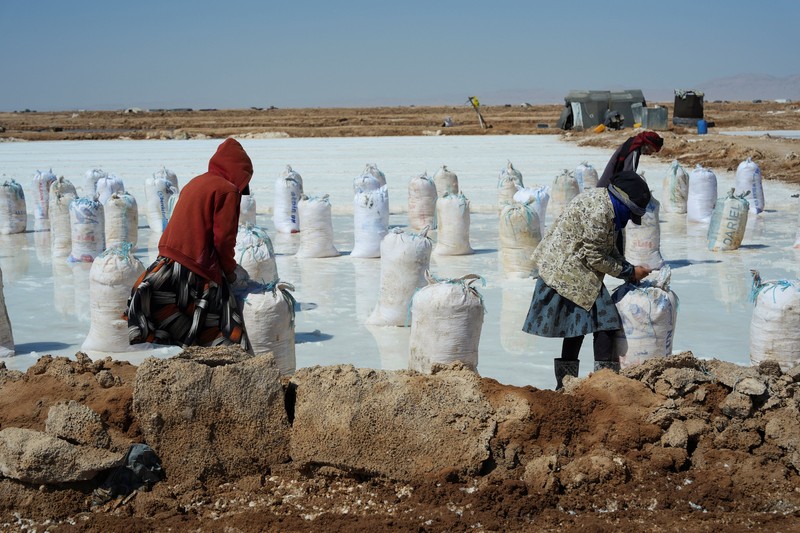 Puluhan pekerja memanen garam dari sumur air asin di gurun Sabkhat al-Muh, wilayah Palmyra, Suriah, dengan bekerja di bawah terik matahari demi upah yang tergolong kecil. (REUTERS/Karam al-Masri)