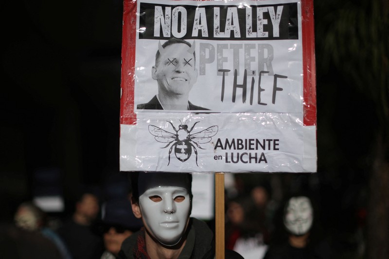 Para pengunjuk rasa membawa plakat dan boneka saat melakukan aksi long march di kediaman Peter Thiel&mdash;salah satu pendiri Palantir dan pemegang saham baru di Vista Energy&mdash;dengan seruan