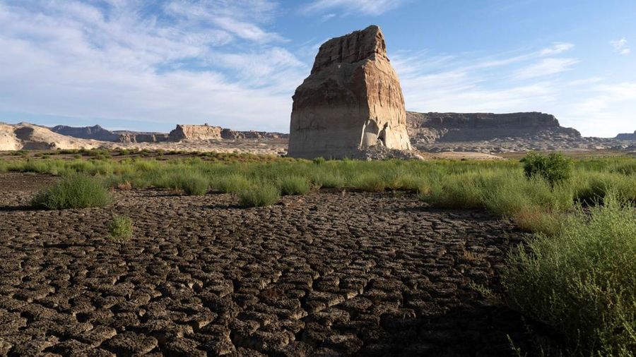 Lone Rock berdiri di tepi bagian Danau Powell yang telah mengering—saat waduk vital tersebut berada pada tingkat permukaan air terendah yang pernah tercatat—di Kawasan Rekreasi Nasional Glen Canyon, Utah, tepat di seberang perbatasan negara bagian dari Page, Arizona, AS, pada 30 Agustus 2026.