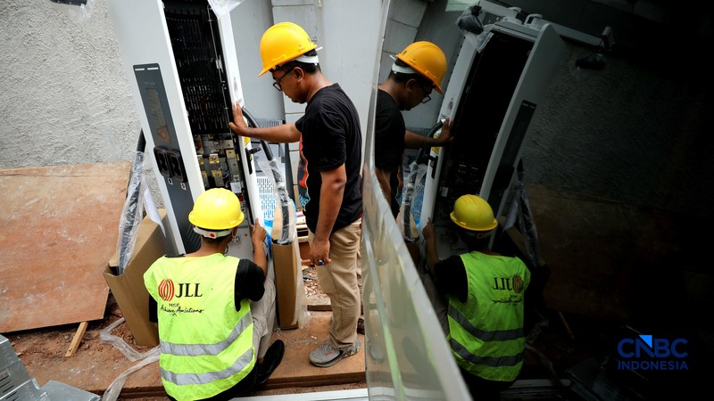 Pekerja menyelesaikan instruksi instalasi Stasiun Pengisian Kendaraan Listrik Umum (SPKLU) di salah satu apartemen di Jakarta, Selasa (1/9/2026). (CNBC Indonesia/Tri Susilo)