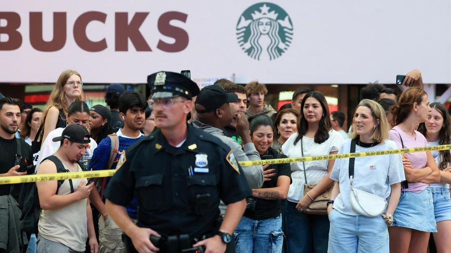 Seorang anggota NYPD berjaga saat warga berkumpul di lokasi kejadian penembakan yang melibatkan petugas kepolisian di Times Square, New York City, AS, pada 31 Agustus 2026.