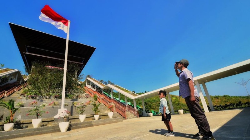 Seorang ayah dan anak putranya melakukan hormat kepada bendera di Istana Wakil Presiden Ibu Kota Nusantara, Penajam Paser, Kalimantan Timur. (Dok. Humas Otorita IKN/Agus Suparto)