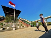Seorang ayah dan anak putranya melakukan hormat kepada bendera di Istana Wakil Presiden Ibu Kota Nusantara, Penajam Paser, Kalimantan Timur. (Dok. Humas Otorita IKN/Agus Suparto)
