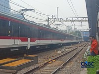 Seorang Petugas palang pintu perlintasan Kereta Api melihat Kereta Rel Listrik (KRL) Commuter Line melintasi di dekat Stasiun Karet, Jakarta, Selasa (1/9/2026). (CNBC Indonesia/Ferry Sandi)