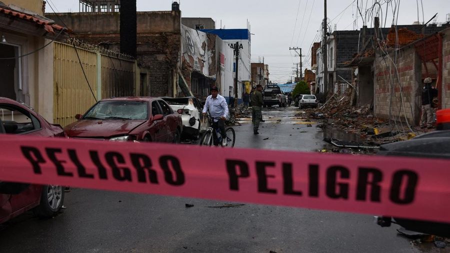 Seorang pria mengendarai sepeda di area yang ditutup di dekat markas polisi kota setelah sebuah bom mobil meledak di luar kantor polisi tersebut pada malam sebelumnyayang menurut laporan media setempat melukai beberapa orangdi Ojocaliente, negara bag