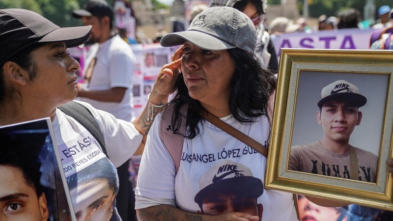 Seorang wanita menenangkan wanita lain yang sedang memegang foto orang hilang dalam sebuah unjuk rasa untuk memperingati Hari Internasional Korban Penghilangan Paksa di Mexico City, Meksiko, pada 30 Agustus 2026.