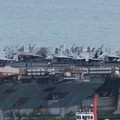 Personnel and aircraft on the deck of the U.S. Navy Nimitz-class aircraft carrier USS Abraham Lincoln as it sails toward Laem Chabang Port before docking for a rest stop following a long deployment in the Middle East, in Chonburi province, Thailand,