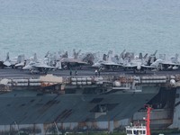 Personnel and aircraft on the deck of the U.S. Navy Nimitz-class aircraft carrier USS Abraham Lincoln as it sails toward Laem Chabang Port before docking for a rest stop following a long deployment in the Middle East, in Chonburi province, Thailand,