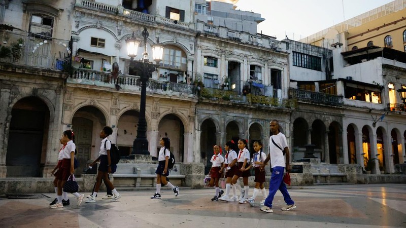 Murid-murid sekolah dasar berseragam berjalan di sepanjang jalan raya Paseo del Prado saat mereka mengikuti hari pertama tahun ajaran 2026-2027 di tengah krisis ekonomi parah yang mendorong pihak berwenang memberikan kelonggaran terkait jadwal, kehadiran, dan ketentuan seragam sekolah, di Havana, Kuba, 1 September 2026.