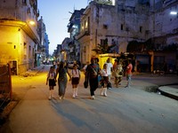 Para orang tua berjalan bersama anak-anak mereka di jalanan saat para siswa mengikuti hari pertama tahun ajaran 2026-2027 di tengah krisis ekonomi parah yang mendorong pihak berwenang untuk memberikan kelonggaran terkait jadwal, kehadiran, dan ketent