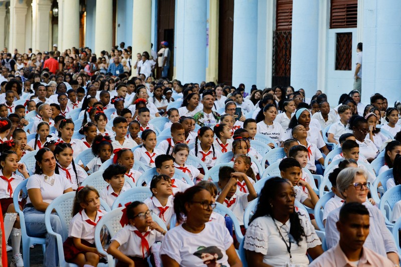 Para orang tua berjalan bersama anak-anak mereka di jalanan saat para siswa mengikuti hari pertama tahun ajaran 2026-2027 di tengah krisis ekonomi parah yang mendorong pihak berwenang untuk memberikan kelonggaran terkait jadwal, kehadiran, dan ketentuan seragam sekolah, di Havana, Kuba, 1 September 2026. (REUTERS/Norlys Perez)