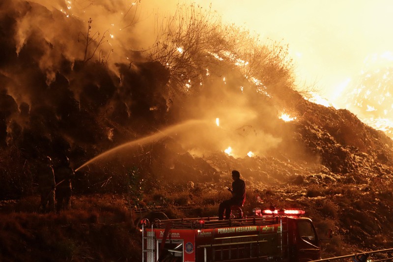 Petugas pemadam kebakaran menyemprotkan air dalam upaya memadamkan kebakaran di Tempat Pembuangan Akhir (TPA) Putri Cempo di Solo, Provinsi Jawa Tengah, Indonesia, pada 2 September 2026. (REUTERS/Stringer)