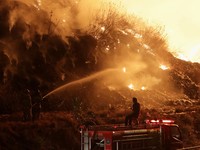 Petugas pemadam kebakaran menyemprotkan air dalam upaya memadamkan kebakaran di Tempat Pembuangan Akhir (TPA) Putri Cempo di Solo, Provinsi Jawa Tengah, Indonesia, pada 2 September 2026. (REUTERS/Stringer)
