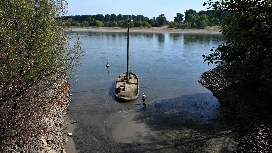 Sebuah bekas kapal penangkap belut yang berlumuran lumpur teronggok di tepi Sungai Rhine saat permukaan air menurun di dekat Neuss, Jerman, pada 4 Agustus 2026.
