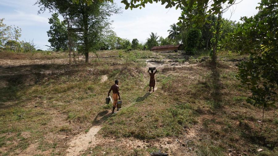 T.B. Leelawathie (49 tahun) dan suaminya, A.M. Pathmasena (48 tahun), membawa air kembali ke rumah mereka setelah mengambilnya dari sebuah sumur yang airnya mulai mengering di Desa Galwela Yaya, Distrik Ampara, Sri Lanka, pada 28 Agustus 2026.