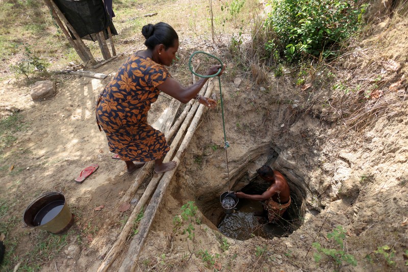 T.B. Leelawathie (49 tahun) dan temannya berjalan membawa ember dan bak saat hendak mandi di sungai yang telah mengering di Desa Galwela Yaya, Distrik Ampara, Sri Lanka, pada 27 Agustus 2026. (REUTERS/Priyanshu Singh)