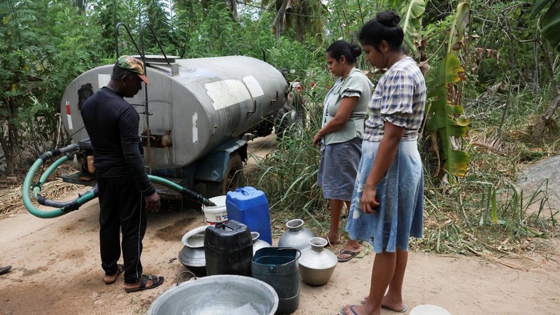 Warga menggunakan pipa untuk mengisi wadah mereka dengan air minum dari truk tangki air di distrik Monaragala, Sri Lanka, pada 24 Agustus 2026.