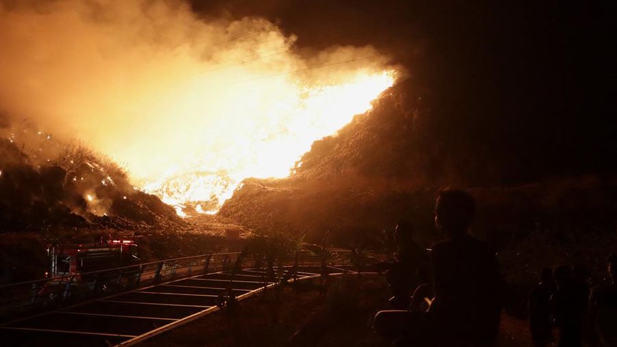 Warga setempat menyaksikan petugas pemadam kebakaran yang berupaya memadamkan api yang membakar Tempat Pembuangan Akhir (TPA) Putri Cempo di Solo, Provinsi Jawa Tengah, Indonesia, pada 2 September 2026.