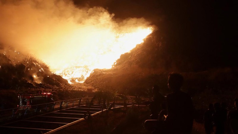 Warga setempat menyaksikan petugas pemadam kebakaran yang berupaya memadamkan api yang membakar Tempat Pembuangan Akhir (TPA) Putri Cempo di Solo, Provinsi Jawa Tengah, Indonesia, pada 2 September 2026.