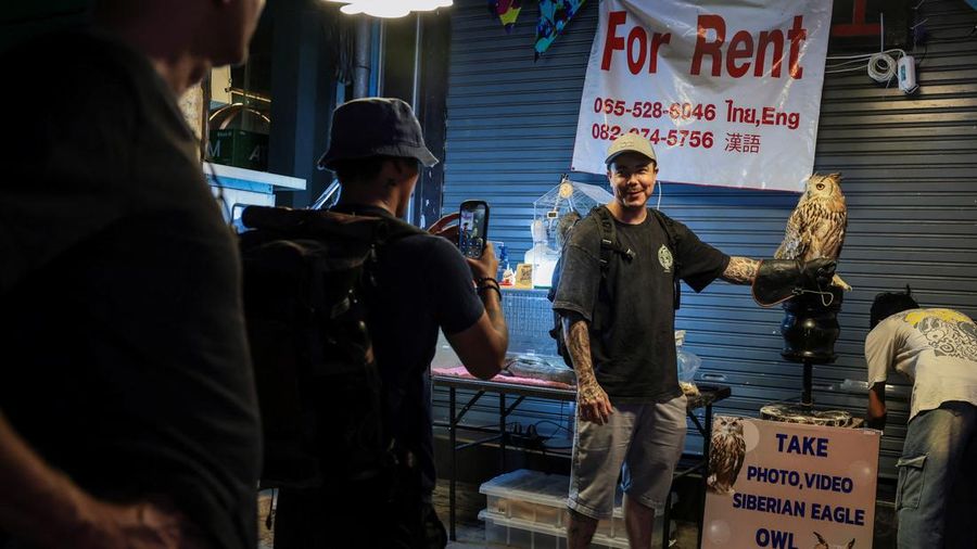 Personel militer AS dari kapal induk kelas Nimitz USS Abraham Lincoln yang sedang bersandar di Pelabuhan Laem Chabang untuk beristirahat setelah penugasan panjang di Timur Tengah—berfoto bersama seekor burung hantu di Walking Street, Pattaya, Thailand, Kamis (3/9/2026). (REUTERS/Chalinee Thirasupa)