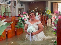 Seorang pengantin wanita Filipina berjalan di lorong Paroki St. Yohanes Pembaptis di tengah banjir di Hagonoy, provinsi Bulacan, Filipina, 1 September 2026. (Ang Tinig - St. John the Baptist Parish Hagonoy/Handout via REUTERS)