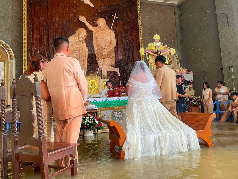 Seorang pengantin wanita Filipina berjalan di lorong Paroki St. Yohanes Pembaptis di tengah banjir di Hagonoy, provinsi Bulacan, Filipina, 1 September 2026. (Ang Tinig - St. John the Baptist Parish Hagonoy/Handout via REUTERS)