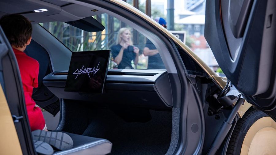 Seseorang sedang memeriksa Tesla Cybercab berwarna emas yang diparkir di luar sebuah bar di pusat kota menjelang sebuah acara di Austin, Texas, AS, pada 3 September 2026.