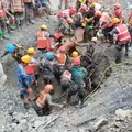 Tim penyelamat membawa seorang penyintas keluar dari terowongan yang terhubung dengan pembangkit listrik tenaga air setelah terjadinya banjir bandang dan tanah longsor yang mematikan, di lokasi yang disebutkan berada di distrik Rasuwa, Nepal, Jumat (