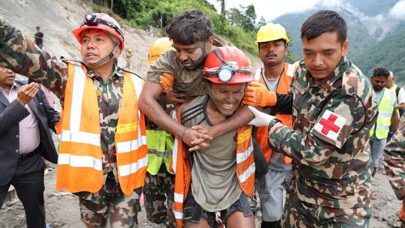 Tim penyelamat membawa seorang penyintas keluar dari terowongan yang terhubung dengan pembangkit listrik tenaga air setelah terjadinya banjir bandang dan tanah longsor yang mematikan, di lokasi yang disebutkan berada di distrik Rasuwa, Nepal, Jumat (4/9/2026). (via REUTERS/Nepal Army)
