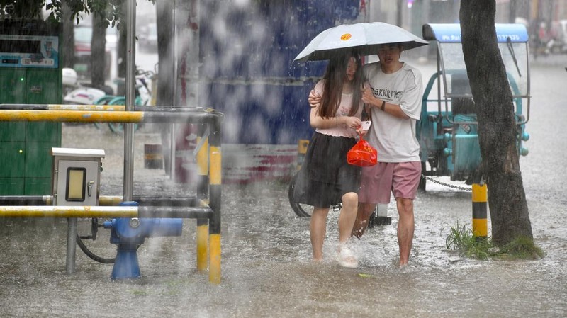 Warga berjalan menyusuri jalan yang tergenang banjir di tengah hujan deras di Fuzhou, Provinsi Fujian, China, Kamis (3/9/2026). (via REUTERS/cnsphoto)