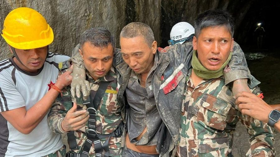 Anggota tim pencarian dan penyelamatan Angkatan Darat Nepal menggotong seorang warga negara Tiongkok setelah ia diselamatkan dalam keadaan hidup dari sebuah terowongan di Proyek Pembangkit Listrik Tenaga Air Upper Trishuli-1 akibat banjir dan tanah l