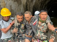Anggota tim pencarian dan penyelamatan Angkatan Darat Nepal menggotong seorang warga negara Tiongkok setelah ia diselamatkan dalam keadaan hidup dari sebuah terowongan di Proyek Pembangkit Listrik Tenaga Air Upper Trishuli-1 akibat banjir dan tanah l