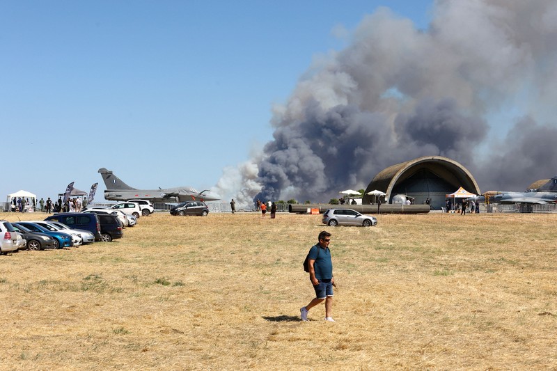 Warga menyaksikan kepulan asap yang membubung setelah jatuhnya jet tempur F-4 Phantom milik Yunani dalam ajang pameran kedirgantaraan Athens Flying Week di Tanagra, Yunani, pada 5 September 2026. (Nikos Mitrousias/Intime via REUTERS)