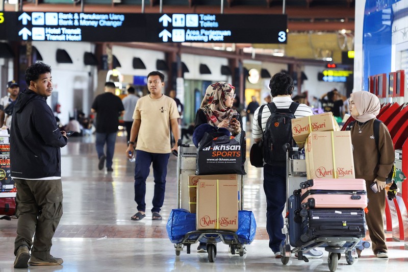 Penumpang yang terdampar menunggu di area check-in saat Bandara Internasional Soekarno Hatta menutup operasinya akibat letusan gunung berapi Gunung Anak Krakatau, di Tangerang, dekat Jakarta, Indonesia, 6 September 2026. (REUTERS/Ajeng Dinar Ulfiana)