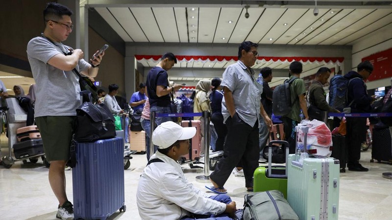 Penumpang yang terdampar menunggu di area check-in saat Bandara Internasional Soekarno Hatta menutup operasinya akibat letusan gunung berapi Gunung Anak Krakatau, di Tangerang, dekat Jakarta, Indonesia, 6 September 2026. (REUTERS/Ajeng Dinar Ulfiana)