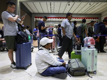 Penumpang yang terdampar menunggu di area check-in saat Bandara Internasional Soekarno Hatta menutup operasinya akibat letusan gunung berapi Gunung Anak Krakatau, di Tangerang, dekat Jakarta, Indonesia, 6 September 2026. (REUTERS/Ajeng Dinar Ulfiana)