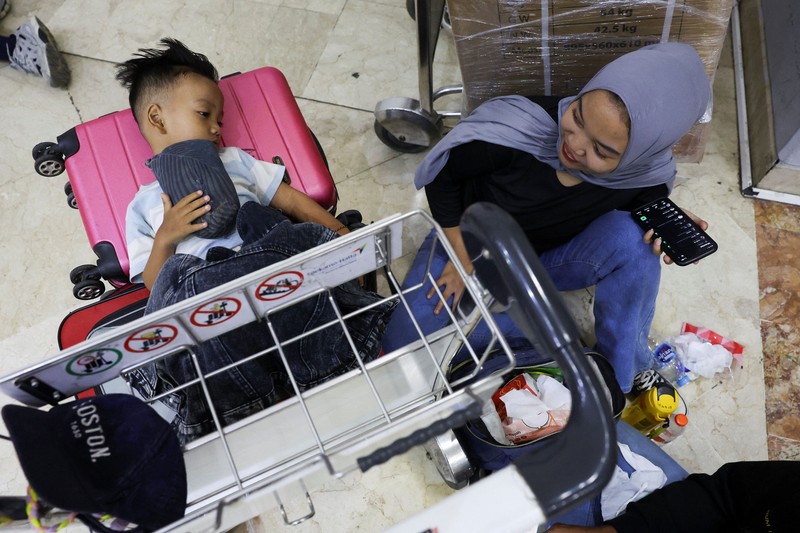 Penumpang yang terdampar menunggu di area check-in saat Bandara Internasional Soekarno Hatta menutup operasinya akibat letusan gunung berapi Gunung Anak Krakatau, di Tangerang, dekat Jakarta, Indonesia, 6 September 2026. (REUTERS/Ajeng Dinar Ulfiana)