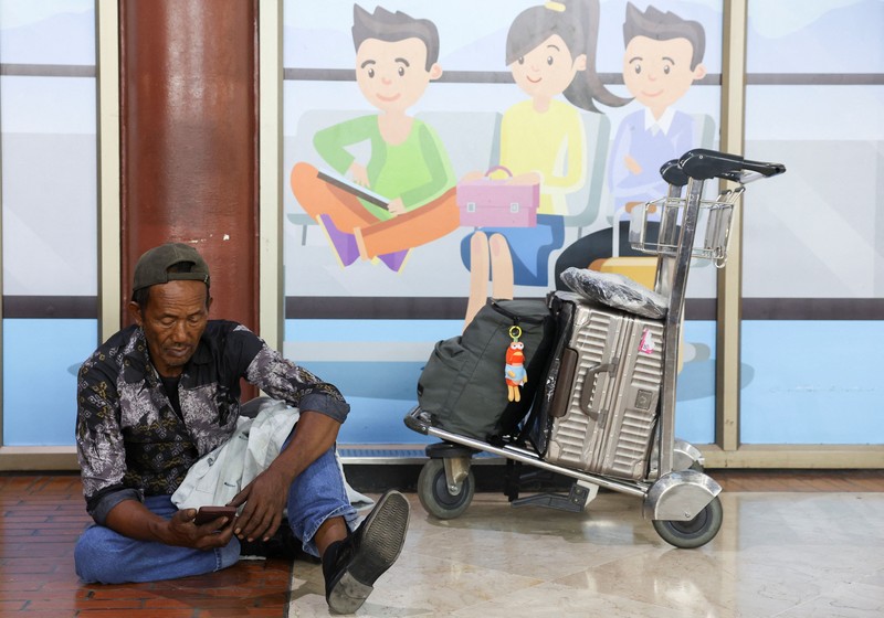 Penumpang yang terdampar menunggu di area check-in saat Bandara Internasional Soekarno Hatta menutup operasinya akibat letusan gunung berapi Gunung Anak Krakatau, di Tangerang, dekat Jakarta, Indonesia, 6 September 2026. (REUTERS/Ajeng Dinar Ulfiana)