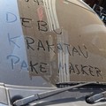 Sebuah mobil terlihat dengan tulisan Awas Debu Krakatau, Pakai Masker yang dibuat menggunakan debu vulkanik yang menempel pada kaca kendaraan akibat paparan erupsi Gunung Anak Krakatau. (Dok. Istimewa)