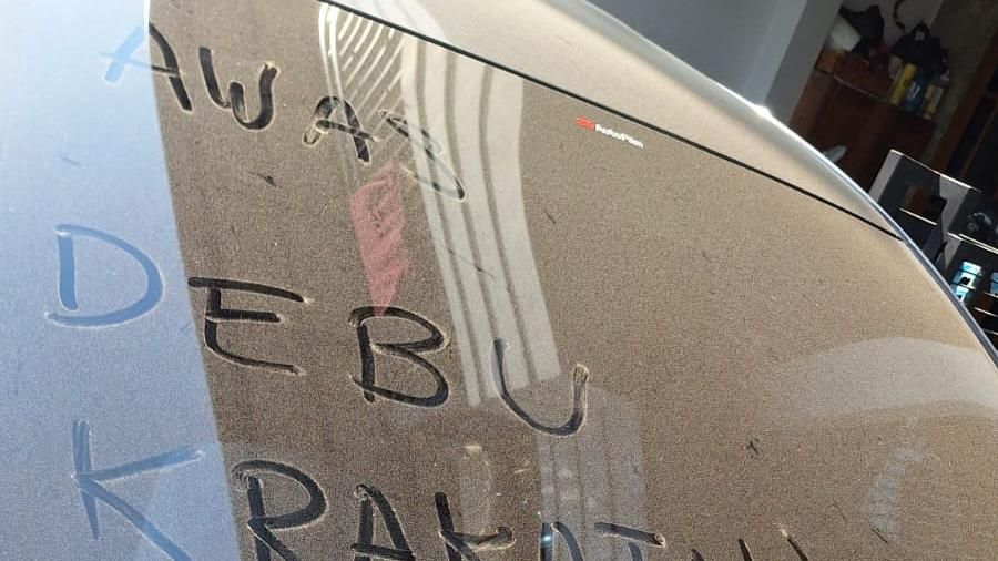 Sebuah mobil terlihat dengan tulisan Awas Debu Krakatau, Pakai Masker yang dibuat menggunakan debu vulkanik yang menempel pada kaca kendaraan akibat paparan erupsi Gunung Anak Krakatau. (Dok. Istimewa)