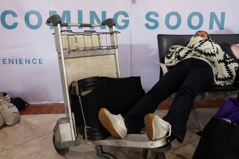 Penumpang yang terdampar menunggu di area check-in saat Bandara Internasional Soekarno Hatta menutup operasinya akibat letusan gunung berapi Gunung Anak Krakatau, di Tangerang, dekat Jakarta, Indonesia, 6 September 2026. (REUTERS/Ajeng Dinar Ulfiana)