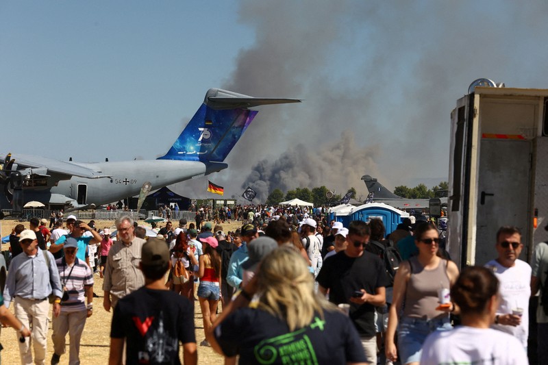 Warga menyaksikan kepulan asap yang membubung setelah jatuhnya jet tempur F-4 Phantom milik Yunani dalam ajang pameran kedirgantaraan Athens Flying Week di Tanagra, Yunani, pada 5 September 2026. (Nikos Mitrousias/Intime via REUTERS)
