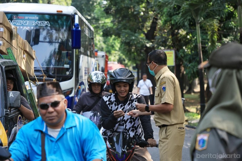 Kecamatan Cipayung membagikan masker ke sejumlah pengendara yang melintas di Jalan Raya Bina Marga, Cipayung, Senin (7/9/2026). (Dok. BeritaJakarta/Andri Widiyanto)