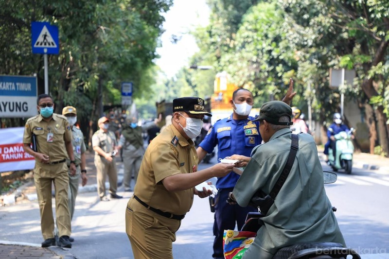 Kecamatan Cipayung membagikan masker ke sejumlah pengendara yang melintas di Jalan Raya Bina Marga, Cipayung, Senin (7/9/2026). (Dok. BeritaJakarta/Andri Widiyanto)