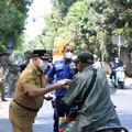 Kecamatan Cipayung membagikan masker ke sejumlah pengendara yang melintas di Jalan Raya Bina Marga, Cipayung, Senin (7/9/2026). (Dok. BeritaJakarta/Andri Widiyanto)