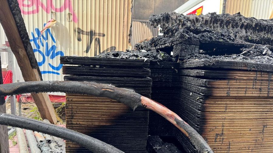 Material bangunan yang hangus terbakar tampak di lokasi konstruksi di area gardu induk saat polisi menyelidiki kebakaran di gardu transformator tersebut—sebuah peristiwa yang semakin meningkatkan kekhawatiran keamanan terkait serangkaian serangan sabotase terhadap jaringan listrik Jerman—di Berlin, Jerman, pada 7 September 2026. Sebuah papan tanda bertuliskan