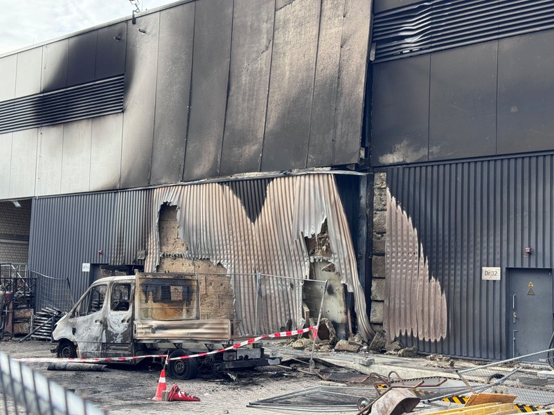 Sebuah kendaraan yang hangus terbakar berada di lokasi konstruksi di area gardu induk saat polisi menyelidiki kebakaran di gardu transformator tersebut&mdash;sebuah peristiwa yang semakin meningkatkan kekhawatiran keamanan terkait serangkaian serangan sabotase terhadap jaringan listrik Jerman&mdash;di Berlin, Jerman, pada 7 September 2026. Sebuah papan tanda bertuliskan
