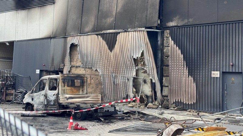 Sebuah kendaraan yang hangus terbakar berada di lokasi konstruksi di area gardu induk saat polisi menyelidiki kebakaran di gardu transformator tersebut—sebuah peristiwa yang semakin meningkatkan kekhawatiran keamanan terkait serangkaian serangan sabotase terhadap jaringan listrik Jerman—di Berlin, Jerman, pada 7 September 2026. Sebuah papan tanda bertuliskan