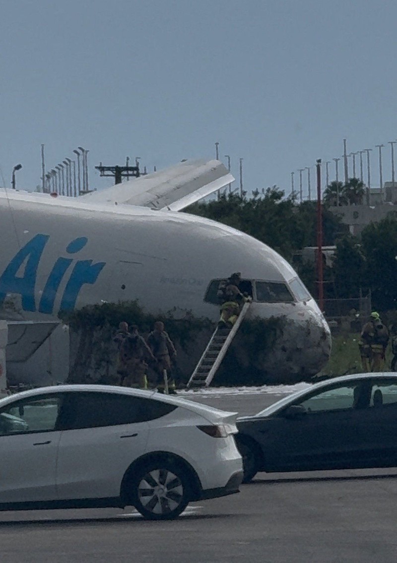 Tim darurat berada di dekat pesawat kargo Amazon Prime Air yang, menurut keterangan pejabat bandara, melampaui batas landasan pacu di Miami, Florida, AS, pada 6 September 2026. (Rohan Ellis/via REUTERS.)